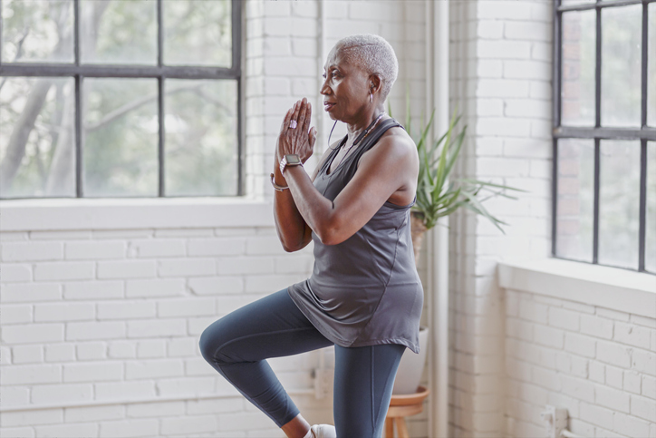 Active senior woman doing yoga at home